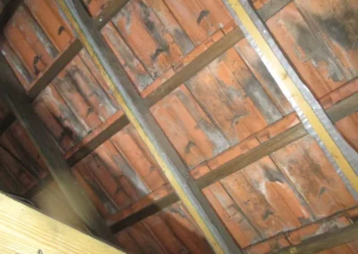 La sous-toiture est absente, exposant directement les chevrons et les tuiles vieillissantes. Cette absence de sous-toiture peut entraîner des infiltrations d'eau, ce qui justifie la nécessité d'une rénovation de la toiture.