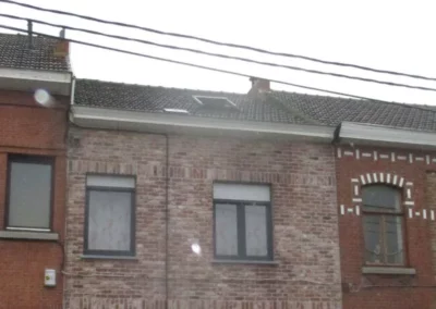 Ancienne toiture avec des tuiles vieillissantes nécessitant un remplacement.