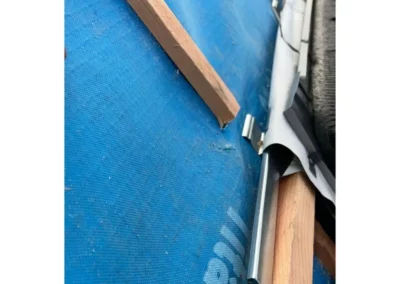 Installation d'une goulotte métallique au-dessus du vélux pour recueillir l'eau de pluie.