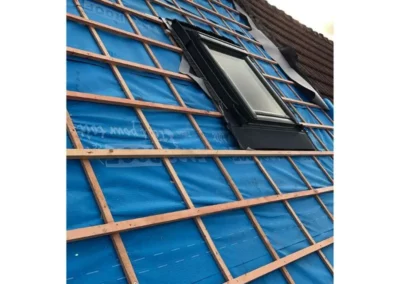 Pose du contre-lattage sur une toiture fixées au-dessus de la sous-toiture bleue pour permettre la bonne ventilation et l'installation des tuiles tout en garantissant l'étanchéité du toit.