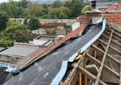 Installation de la sous-toiture sur les chevrons d'une maison. Cette membrane est posée pour empêcher les infiltrations d'eau sous les tuiles, garantissant une bonne étanchéité de la toiture.