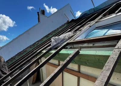 installation d'une nouvelle poutre en bois pour renforcer la charpente. Ce renforcement est nécessaire pour soutenir les chevrons et garantir la solidité de la future couverture de toiture.