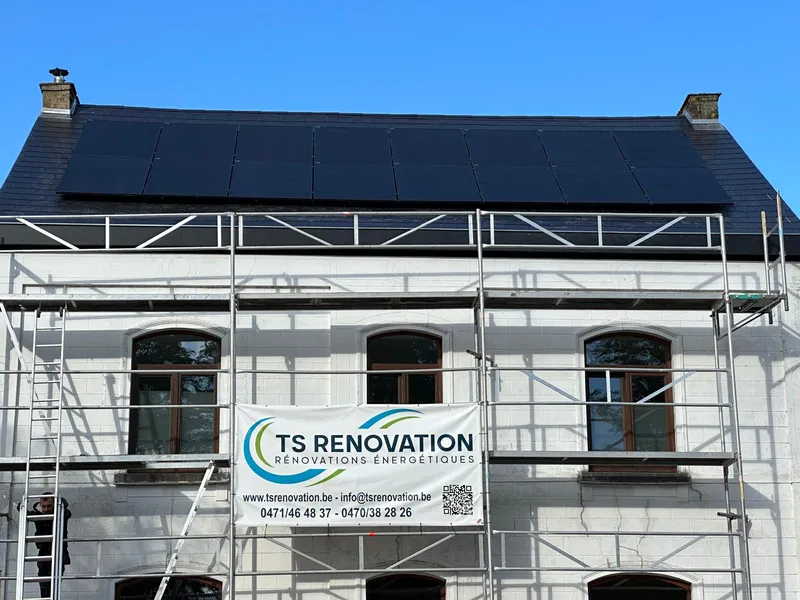 Chantier avec réfection toiture, pose de tuile noire et installation de panneaux photovoltaïques sur le toit