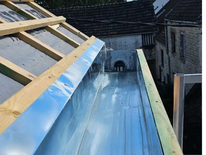 Travaux de zinguerie avec pose d'une feuille de zinc dans cheneau pour obtenir une étanchéité parfaite du bac.