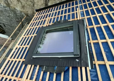 Installation du Velux sur le toit avec jonctions étanches dans la structure de la toiture.