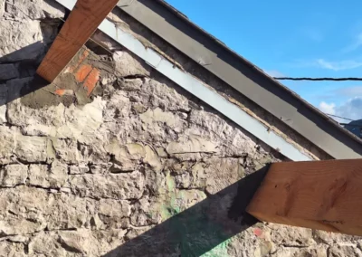 Les nouvelles pannes de toiture sont alignées avec la pente du toit et scellées dans les murs.